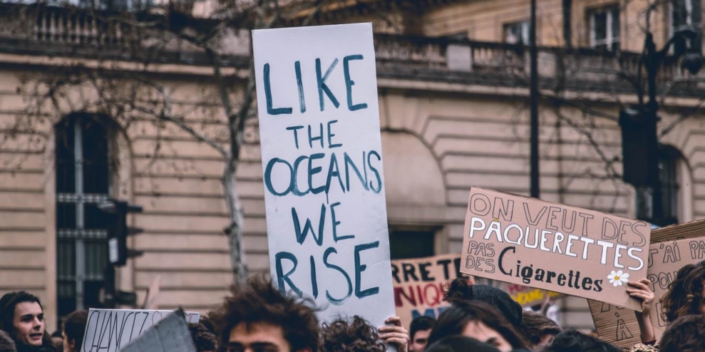 Cartello di protesta studentesca come gli oceani ci solleviamo inquinamento atmosferico