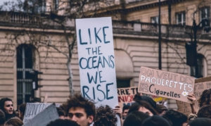 Cartello di protesta studentesca come gli oceani ci solleviamo inquinamento atmosferico